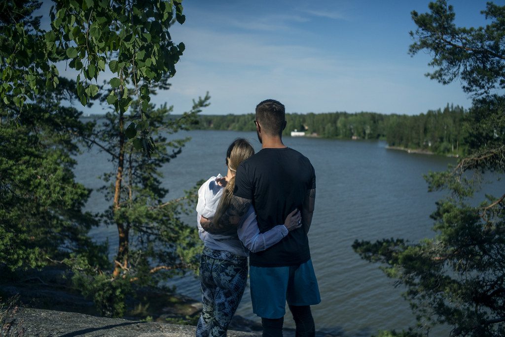 Pariskunta halaa katsellessa järvimaisemaa